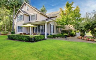 Home with lap siding, surrounded by lawn, trees, and shrubs